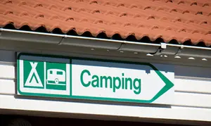 Foto på en skylt där det står "camping". 