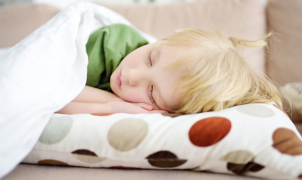 Foto på barn som blundar eller sover. 