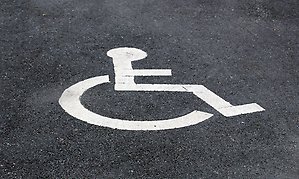 Foto av handikappsymbolen målad på asfalt. 